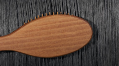 Black hair being combed with a brush