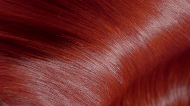 Flowing glossy red dyed hair making slow motion waves