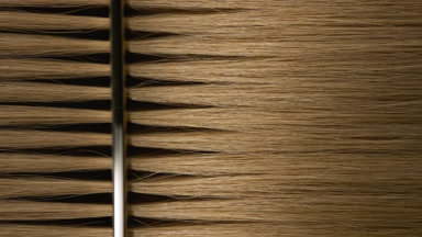 Honey brown hair being combed with silver comb