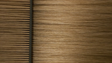Black plastic comb combing honey brown hair