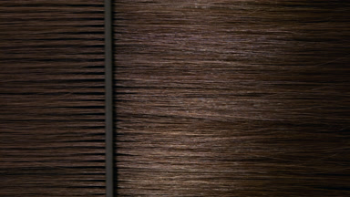 Black plastic comb combing brown hair