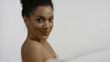 Water reflection of young woman strokes shoulder and arm turning