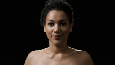 Slim African young woman looks at the camera moving her head up