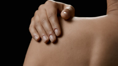 Young African American woman strokes her shoulder
