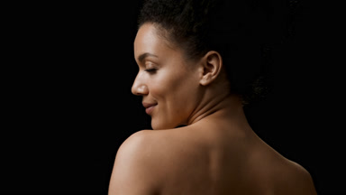 Black-haired African American woman turns to the camera smiling