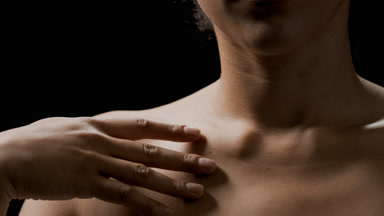 Young African American woman strokes her clavicles