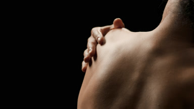 Brunette African woman with curly hair strokes shoulder blade