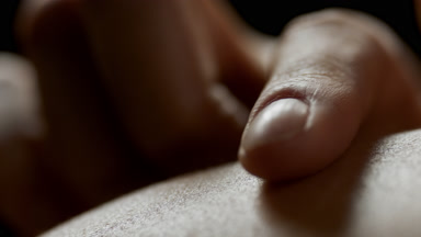 Macro shot of young African American woman strokes her skin