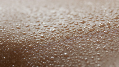 A lot of water drops on moving skin of African American woman