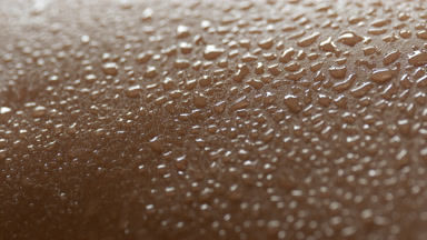A lot of water drops on moving skin of African female model