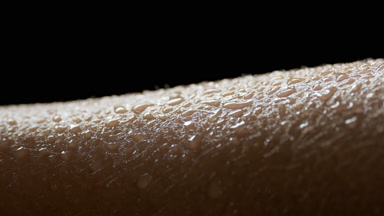 Macro shot of water drops on moving skin of African female model