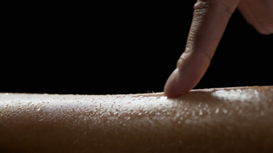 Macro shot of African woman strokes her good-looking wet skin