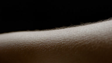 Water is sprayed on hairy skin of young African American woman