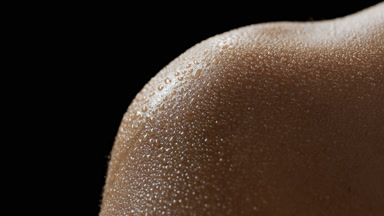 Macro shot of wet moving skin of African American female model