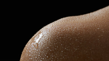 Water drips on wet skin of young African American female model