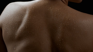 Good-looking slim African female model moves her wet shoulders
