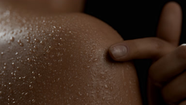 Young good-looking African American woman strokes wet shoulder