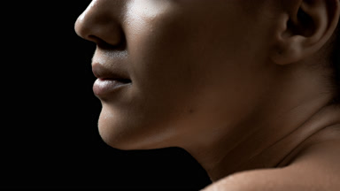 Brunette African woman with wet shoulder moves her head up