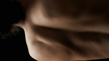Good-looking slim African American female model moves scapulae