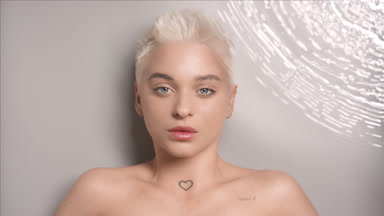 Attractive blonde woman blinks looking at camera through water