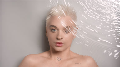 Caucasian woman turns to the camera looking at it through water