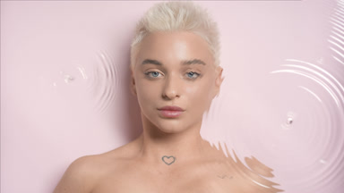 Woman with short hair turns to the camera through rippling water