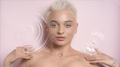 Blonde Caucasian woman strokes clavicles through rippling water