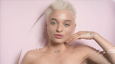 Blond woman strokes her jawline smiling through rippling water