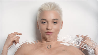 Underwater portrait of cute Caucasian woman strokes collarbones