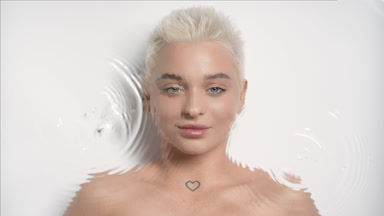 Water portrait of attractive blonde Caucasian woman opens eyes