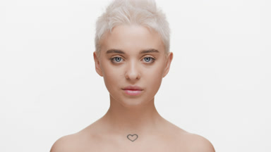Blonde woman moves head up, opens eyes and looks at the camera