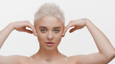 Young woman with short light hair strokes jawline moving head up