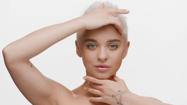 Pretty woman with short white hair strokes forehead and jawline