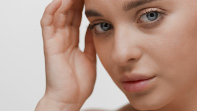 Young woman strokes face moving head up and looking at camera
