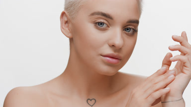 Young slim pretty Caucasian woman closes eyes stroking jawline