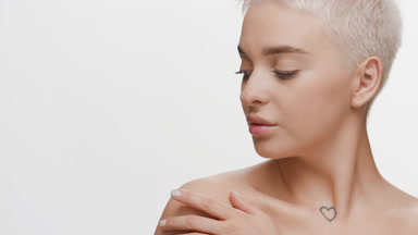 Slim Caucasian woman strokes clavicles turning head to camera