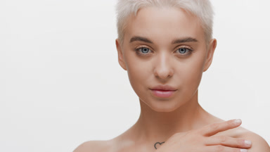 Gorgeous young Caucasian woman strokes collarbones turning head