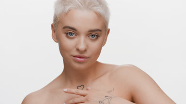 Attractive slim blonde Caucasian woman strokes clavicles turning