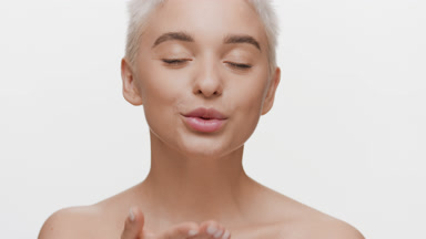 Gorgeous young slim light-haired Caucasian woman blows a kiss