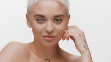 Pretty slim woman strokes her jawline turning head to the camera
