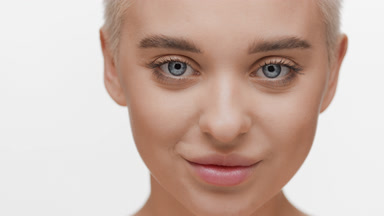 Beautiful blond Caucasian woman opens her eyes and smiles wide