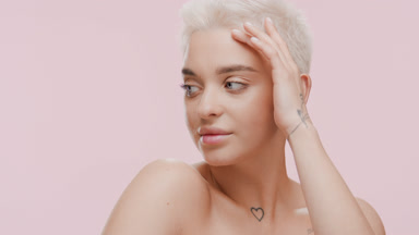 Pretty young slim woman strokes face turning head to the camera