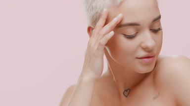 Cute young slim Caucasian woman strokes face with closed eyes