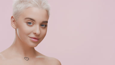 Cute slim young woman strokes clavicles turning body and smiling