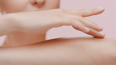 Attractive young slim Caucasian woman strokes forearm and smiles