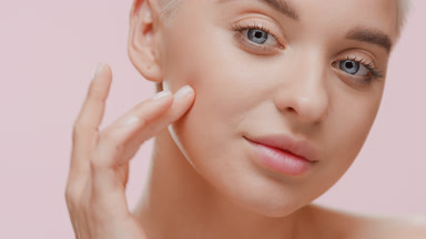 Woman touches cheek tapping with her walking fingers and smiles