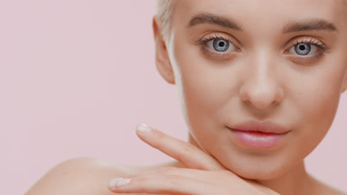 Good-looking blond Caucasian woman strokes her face turning head
