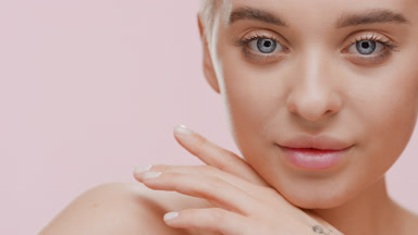 Pretty slim woman strokes face looking at the camera and smiling