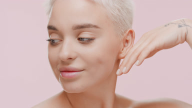 Beautiful slim woman with fair hair strokes jawline turning head