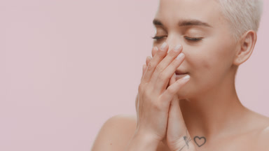 Cute woman rubs her hands and smells them enjoying the fragrance